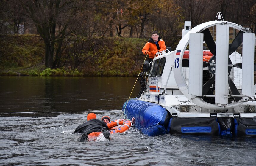Спасатели затаскивают утопающего на борт вездехода