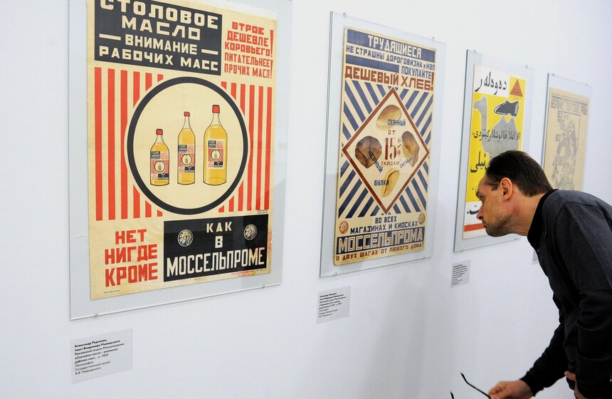 Посетитель у рекламного плаката Моссельпрома "Столовое масло - внимание рабочих масс..." (А.Родченко, В.Маяковский, 1923г.) на выставке "Все на продажу" в МГВЗ "Новый Манеж". Фото: ТАСС/ Валерий Шарифулин