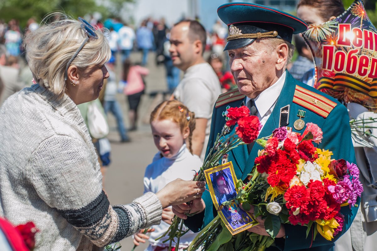 Как семьи отмечают день победы. Цветы ветеранам. Ветеранам дарят цветы. День Победы ветераны. Гвоздики ветеранам.