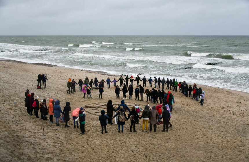 Закончился праздник традиционным флешмобом на берегу Балтийского моря – школьники выстроились в форме герба национального парка.