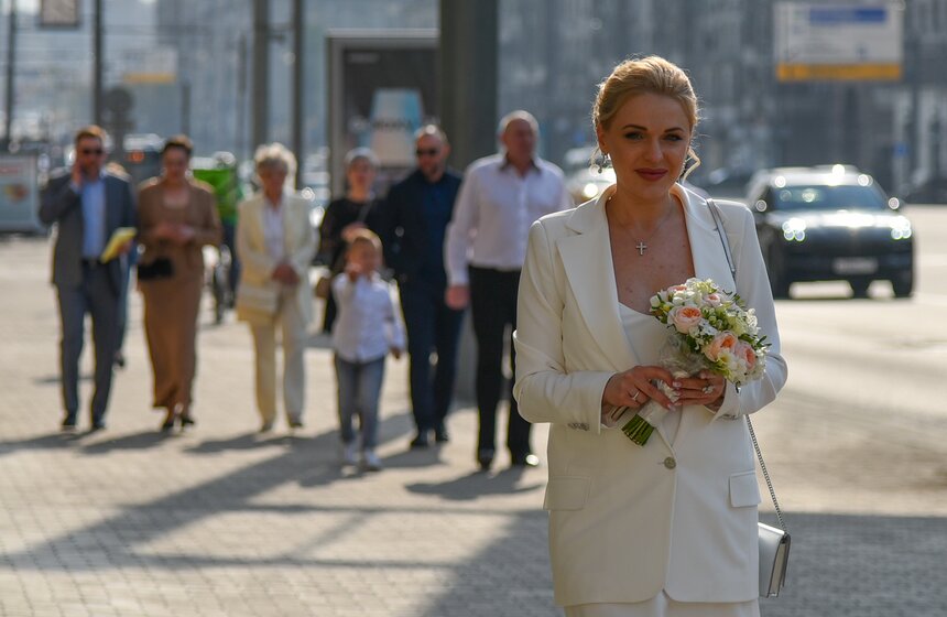 Невзирая на не самую популярную дату, возле ЗАГСа на Кутузовском время от времени все равно собирались небольшие очереди. Одни невесты только заходили в красивые двери, нервничая и в спешке поправляя платья, другие выходили с гордой и довольной улыбкой на лице – они уже жены!