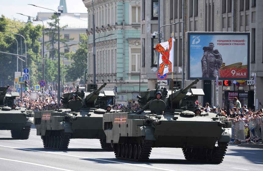 Зрители наблюдают за проходом колонны военной техники 9 фото