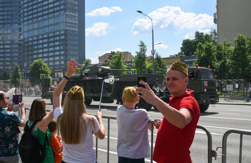 Зрители наблюдают за проходом колонны военной техники 14 фото