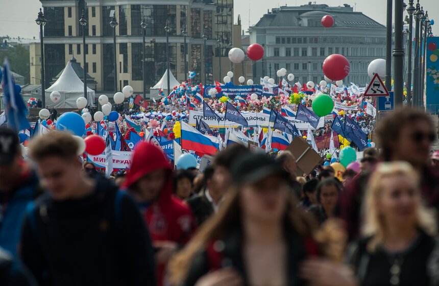 Участники праздничного шествия несли флаги, цветы и воздушные шары.