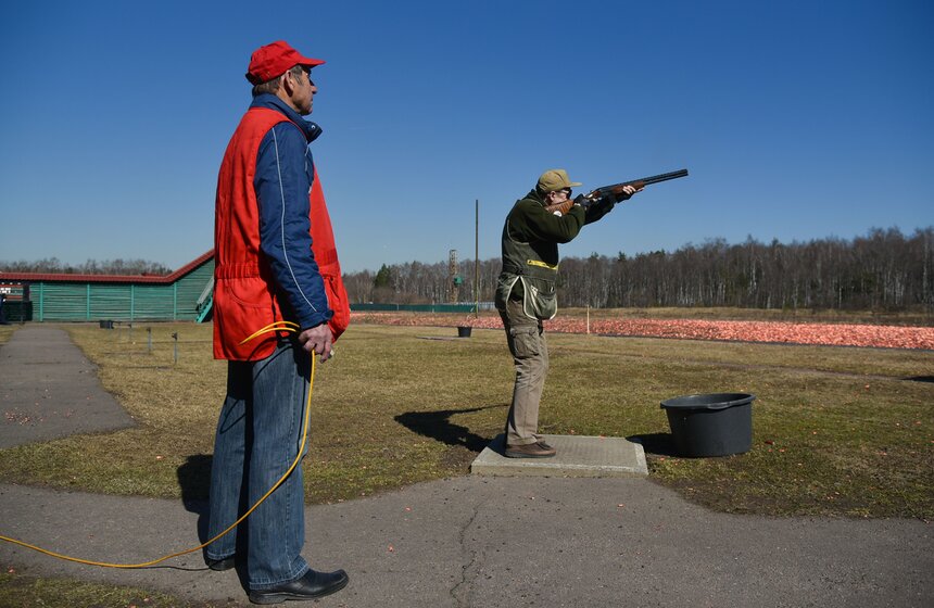 Эта площадка – одна из двух, использующихся в олимпийских дисциплинах. Она называется трап, или по-русски – траншея. Суть в том, что перед позицией стрелка вырыт ров, в котором установлены машинки для подачи мишеней. Сложность в том, что стрелок не знает, какая из них подаст мишень: левая, правая или центральная. Сбивать мишень можно одним из двух патронов.