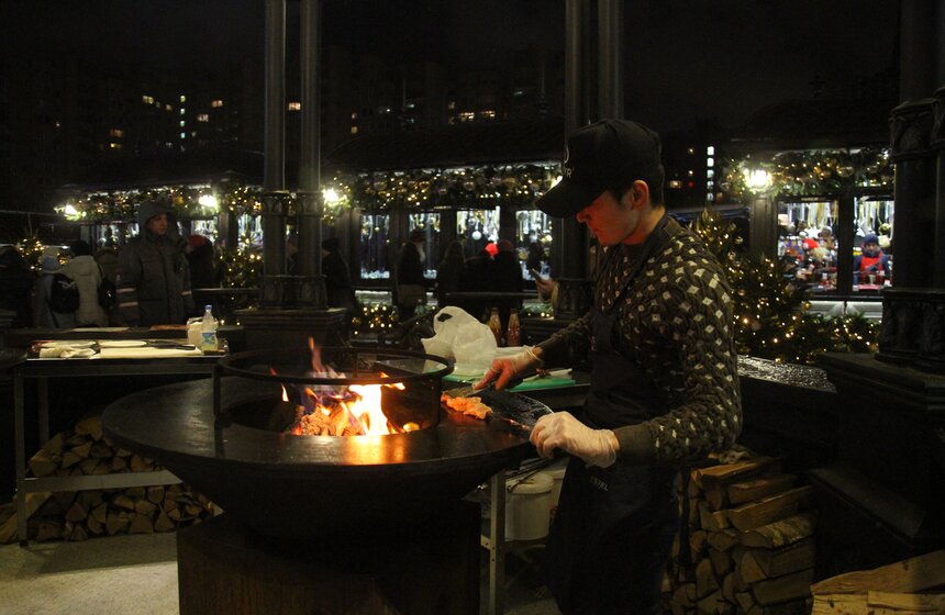 На большой жаровне готовят праздничные блюда.