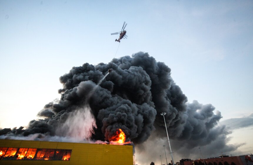 Торговый центр "Синдика" загорелся 8 октября. Огонь вспыхнул на складе и распространился на подземную парковку. Сначала площадь возгорания составила 1 тысячу квадратных метров, затем достигла 55 тысяч квадратных метров. Потушить пожар удалось лишь к утру следующего дня. В его ликвидации участвовали три вертолета. Пострадали три человека, которые отравились угарным газом. Потери собственников "Синдики" составили около 4 миллиардов рублей. После происшествия владельцы сгоревшего ТЦ решили построить на его месте новый комплекс. Причиной пожара стал поджог. Делом занимаются полицейские. Фото: АГН Москва/Ведяшкин Сергей.