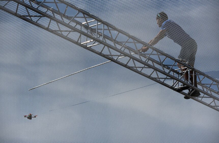 Хоть дроны и маленькие, но страсти на гоночной трассе кипели совершенно взрослые! Скорость не прощает ошибок никому – будь ты пилот Формулы-1 или оператор БПЛА. Вот один из участников не справился с управлением в крутом вираже и сошел с дистанции. Технические службы пытаются высвободить его из нейлоновой сети.