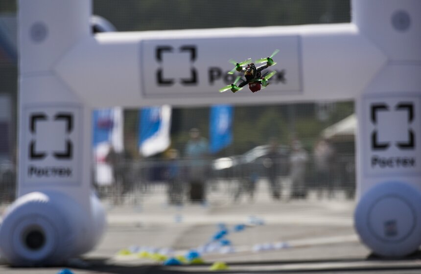 На трассе цветными конусами выложены траектории, по которым дроны должны пролетать, огибая при этом препятствия: надувные столбы, арки и ворота.