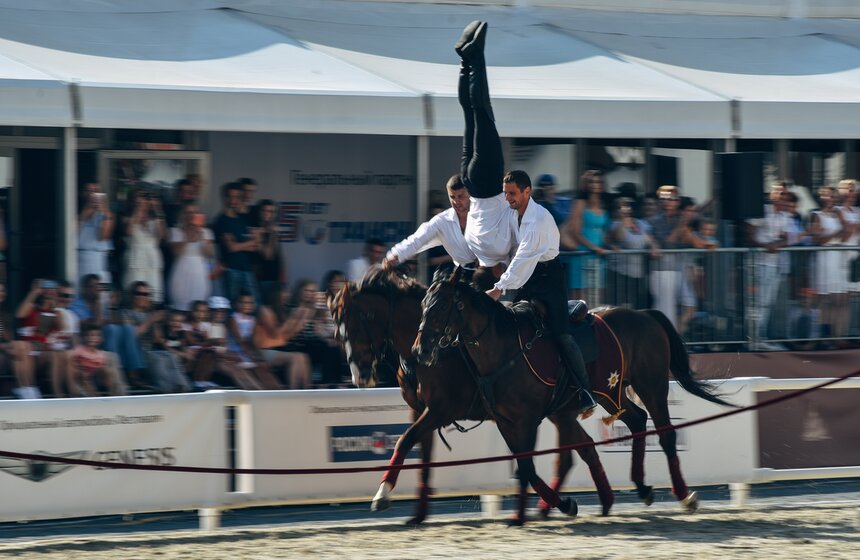 Всадники демонстрируют элементы обязательной и вольной джигитовки различного уровня сложности – "Казачий вис", "Казачий обрыв", стойки вниз головой, вертушки, соскоки, пролазы под шеей лошади, на полном скаку поднимают предметы с земли