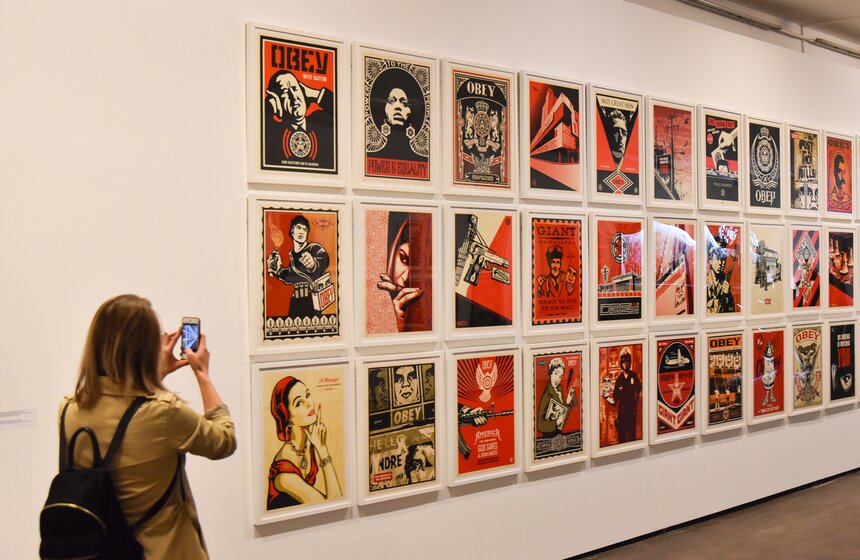 Искусство Шепарда Фэйри, по определению самого художника, — реакция на форс-мажорные обстоятельства, попытка борьбы с помощью провокационного языка уличного искусства