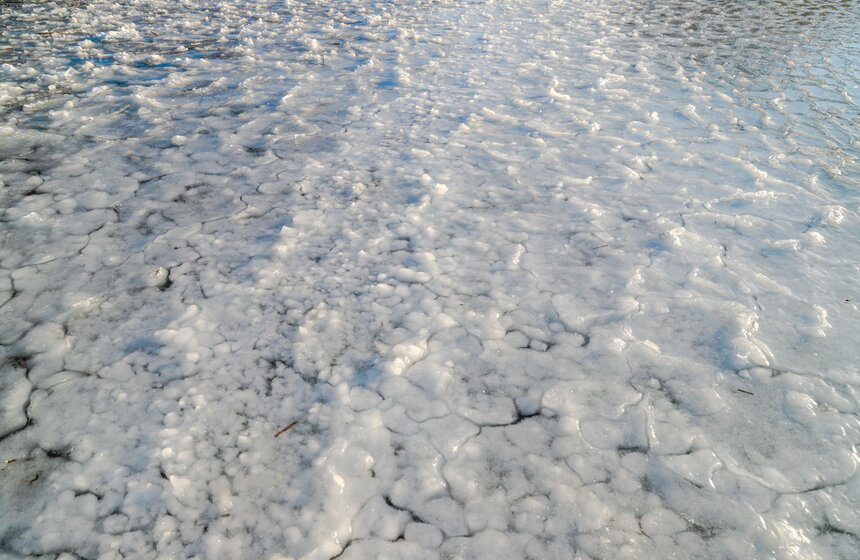 Если на поверхность замерзающей воды выпадает снег, образуется вязкая снежная каша - снежура, когда она смерзается получается такой белый и неоднородный лед