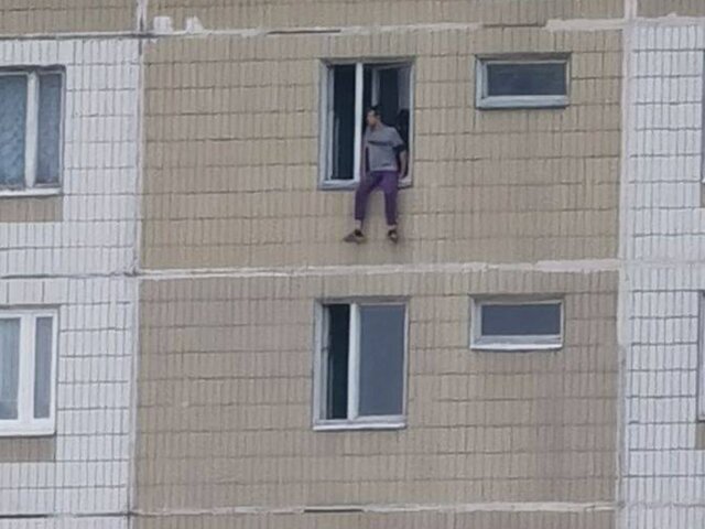 Мужчина угрожает выпрыгнуть из окна последнего этажа дома в Братееве