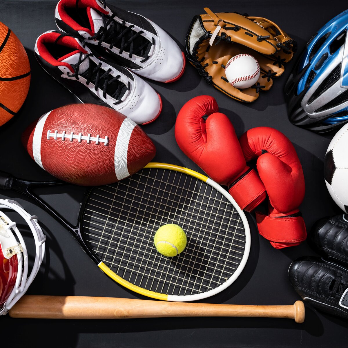 Collection of sports equipment including football, basketball, tennis racket, boxing gloves and athletic shoes