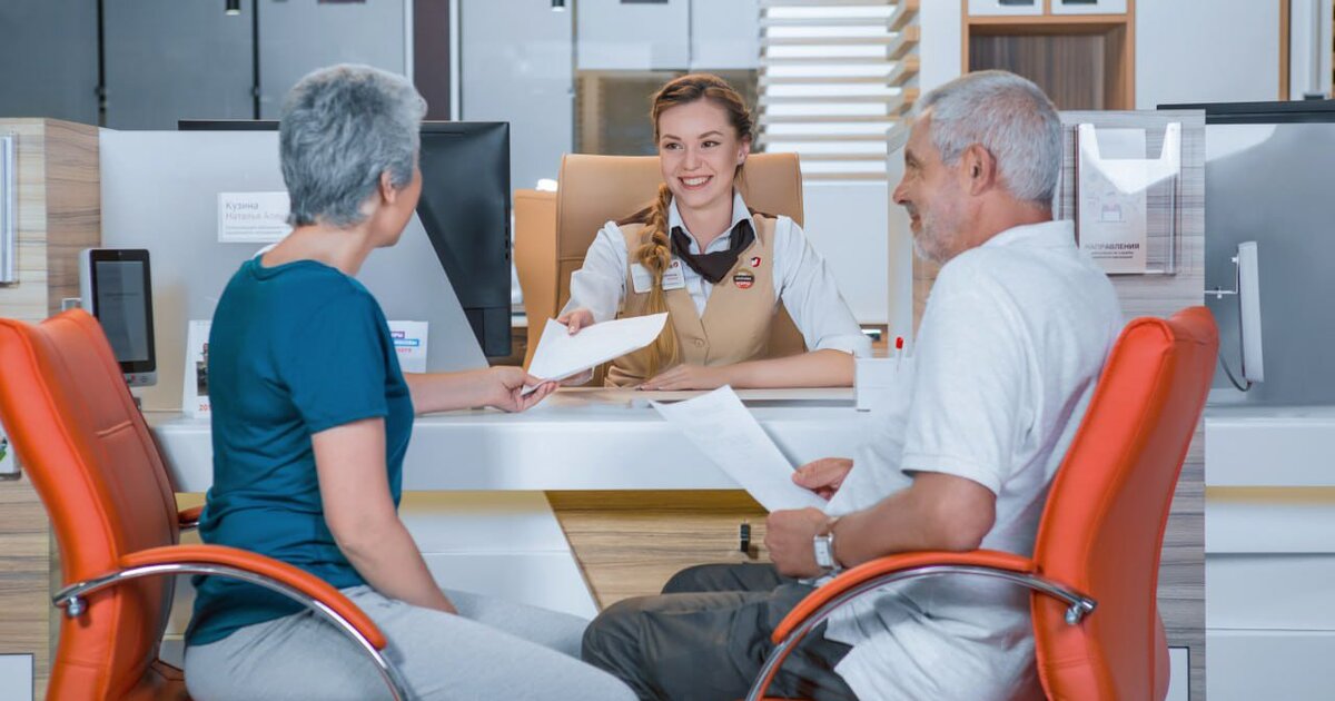 сотрудник мфц помогает посетителю